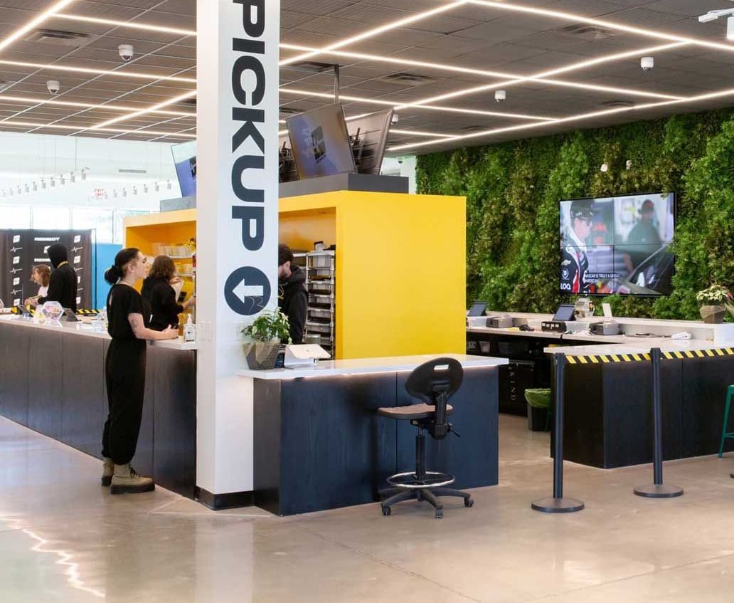 Bright dispensary interior with pickup counter and green living wall